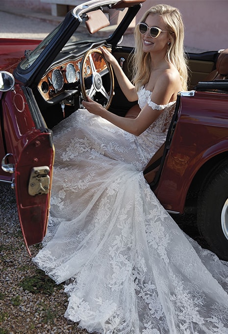 bride sitting in old school car wearing ​Pronovias Phuket wedding dress
