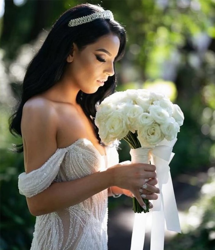 side view of bride smelling flowers