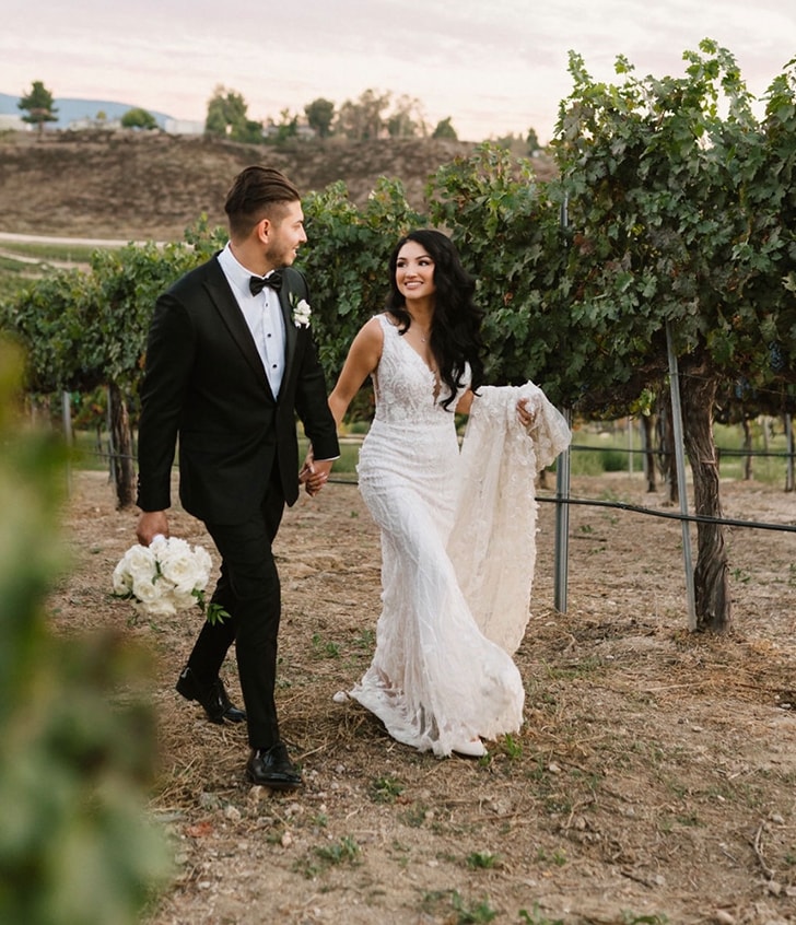 husband and wife walking through the grass