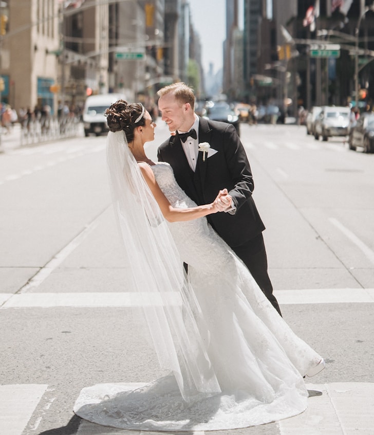 bride and husband posing for portrait on main street