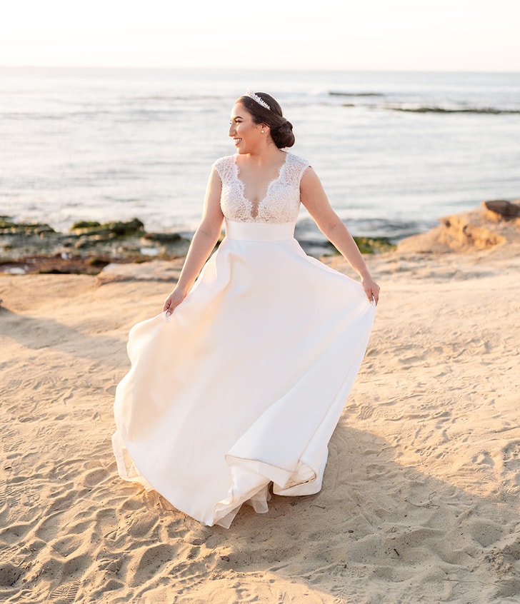 bride on beach holding her dress