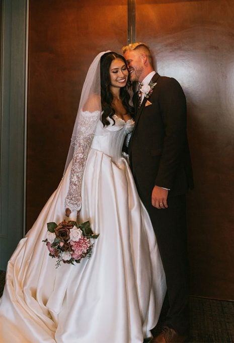 husband kissing bride gabby on the cheek on their wedding day