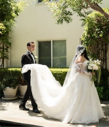 groom holding bride wedding gown